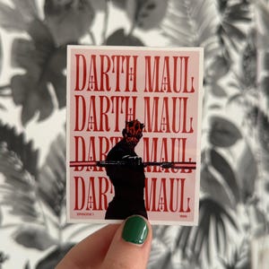 May include: A pink and red sticker featuring Darth Maul from Star Wars Episode I. The sticker has the text "Darth Maul" repeated four times.