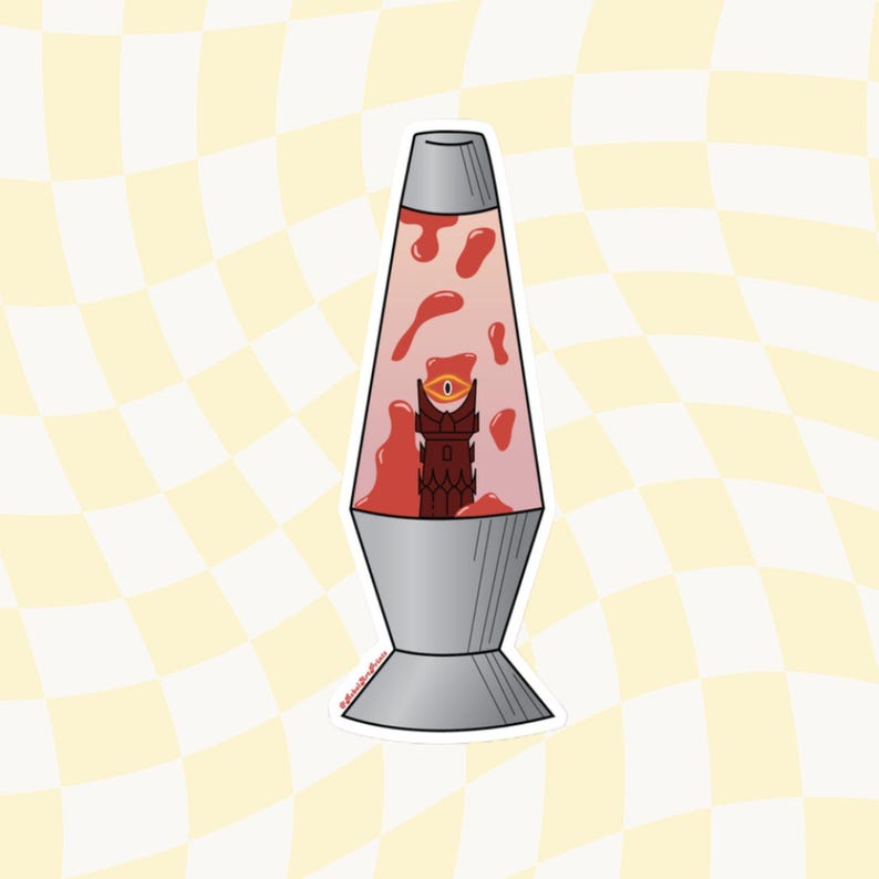 May include: A red lava lamp with a dark red tower with a single eye inside. The tower is in the center of the lamp.