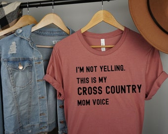 Könnte beinhalten: Ein staubiges rosafarbenes T-Shirt mit schwarzem Text, der "Ich schreie nicht. Das ist meine Cross-Country-Mutter-Stimme." lautet.