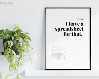 May include: A framed print with the text "Relax. I have a spreadsheet for that." in a bold, black font. The print includes a gray graphic of charts and graphs. A potted plant with green leaves sits on a white shelf.
