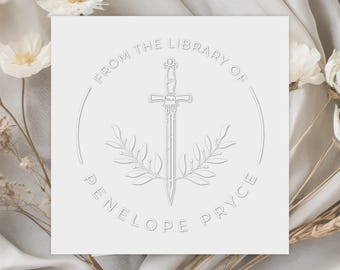 May include: White embossed paper card with a circle design featuring a sword with a wreath of leaves and the text "From the Library of Penelope Pryce".