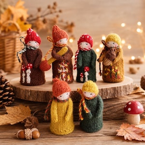 Puede incluir: Colección de siete muñecos de gnomos tejidos a mano. Cada muñeco tiene un atuendo único, incluyendo sombreros, bufandas y abrigos en varios colores otoñales como marrón, naranja, amarillo y verde. Algunos muñecos sostienen pequeños accesorios.