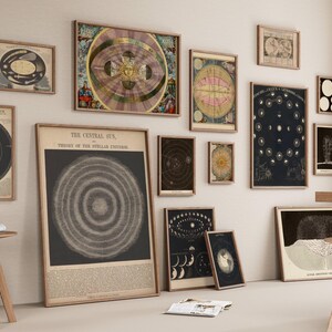 May include: A collection of framed vintage astronomical charts and illustrations, including depictions of the solar system, constellations, and celestial bodies. The artwork is displayed on a neutral-colored wall, creating a gallery-like atmosphere.