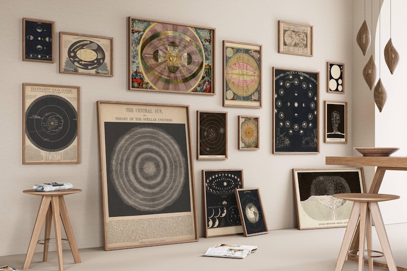 May include: A collection of framed vintage astronomical charts and illustrations, including depictions of the solar system, constellations, and celestial bodies. The artwork is displayed on a neutral-colored wall, creating a gallery-like atmosphere.