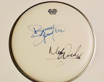 Pele de bateria autografada por Bruce Springsteen e Max Weinberg com certificado de autenticidade.