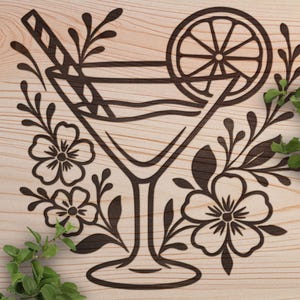 May include: A wooden sign with a laser-cut design of a cocktail in a martini glass, garnished with a lemon slice and a straw. The design is surrounded by floral and leaf accents. The wood has a light, natural finish.