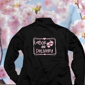 May include: Black zip-up jacket with a pink graphic on the back that says "Labour and Delivery" with a heart and two baby footprints.