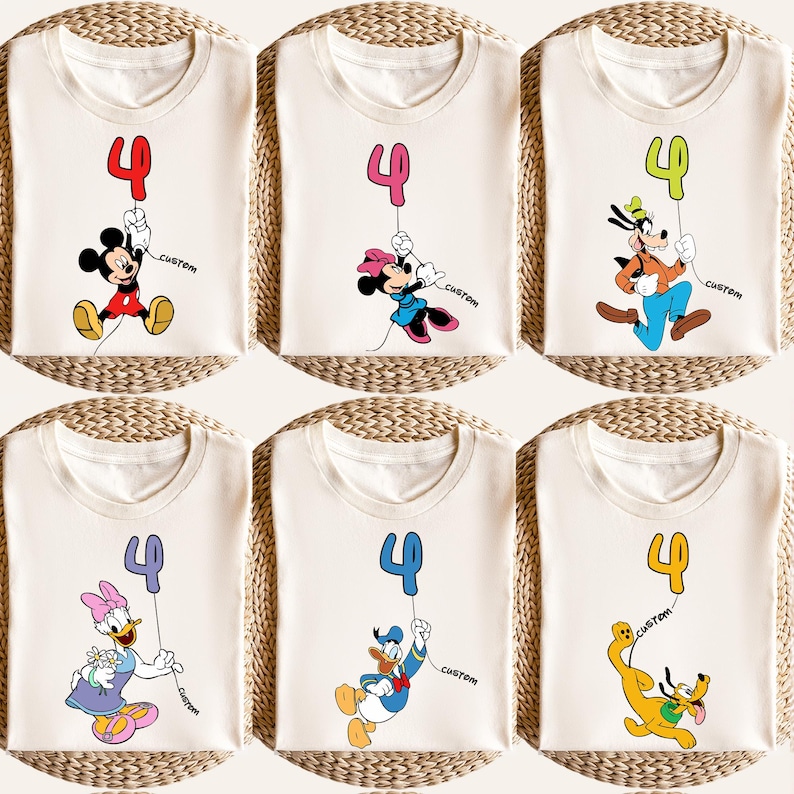 May include: Six cream-colored t-shirts featuring cartoon characters holding a number 4 balloon. Mickey Mouse, Minnie Mouse, Goofy, Daisy Duck, Donald Duck, and Pluto are depicted. Each shirt has the word "custom" printed on it.