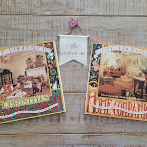 May include: Two hardcover books with colorful covers featuring illustrations of rooms decorated for Christmas and home decor. The books are titled "Marc Engelbreits Christmas Companion" and "Marc Engelbreits Home Companion".