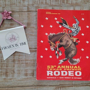 May include: A red and white program for the 53rd Annual Texas Prison Rodeo. The program features a black and white illustration of a cowboy riding a bucking horse. The text "OFFICIAL SOUVENIR PROGRAM 1964" is printed at the top of the program. The text "53rd ANNUAL TEXAS PRISON RODEO" is printed in large letters at the bottom of the program. The text "HUNTSVILLE EACH SUNDAY IN OCTOBER" is printed below the rodeo title.
