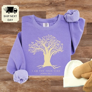 May include: Purple sweatshirt with a yellow tree graphic and the text "I am the true vine John 15:1".