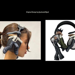 May include: A pair of black headphones with a unique design featuring two small figures holding onto the earcups. The figures are wearing black and white clothing and appear to be running.