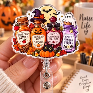 May include: A decorative badge reel featuring a Halloween-themed illustration of four potion bottles labeled Apple Crisp Ativan, Pumpkin Spice Propofol, Maple Cinnamon Haldol, and Spiced Vanilla Versed, with a black cat, pumpkins, and a ghost.