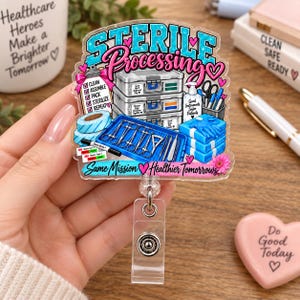 Op de afbeelding: Een badgehouder met een afbeelding met de tekst Sterile Processing en Same Mission Healthier Tomorrows. Het ontwerp bevat medische voorraadbakken, een checklist, chirurgische instrumenten op een blauw dienblad en roze hartjes.