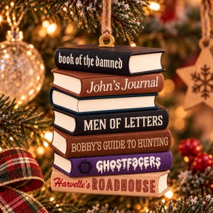 May include: A hanging Christmas tree ornament featuring a stack of six miniature books. The spines are labeled: book of the damned, John's Journal, MEN OF LETTERS, BOBBY'S GUIDE TO HUNTING, GHOSTFACERS with a symbol, and Harvelle's ROADHOUSE.