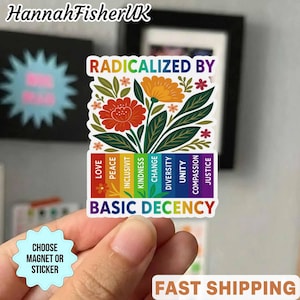 Op de afbeelding: Een kleurrijke sticker met de tekst "RADICALIZED BY BASIC DECENCY". De sticker heeft een bloemenontwerp met rode en oranje bloemen, groene bladeren en een regenboogbalk met woorden als "LOVE" en "JUSTICE".