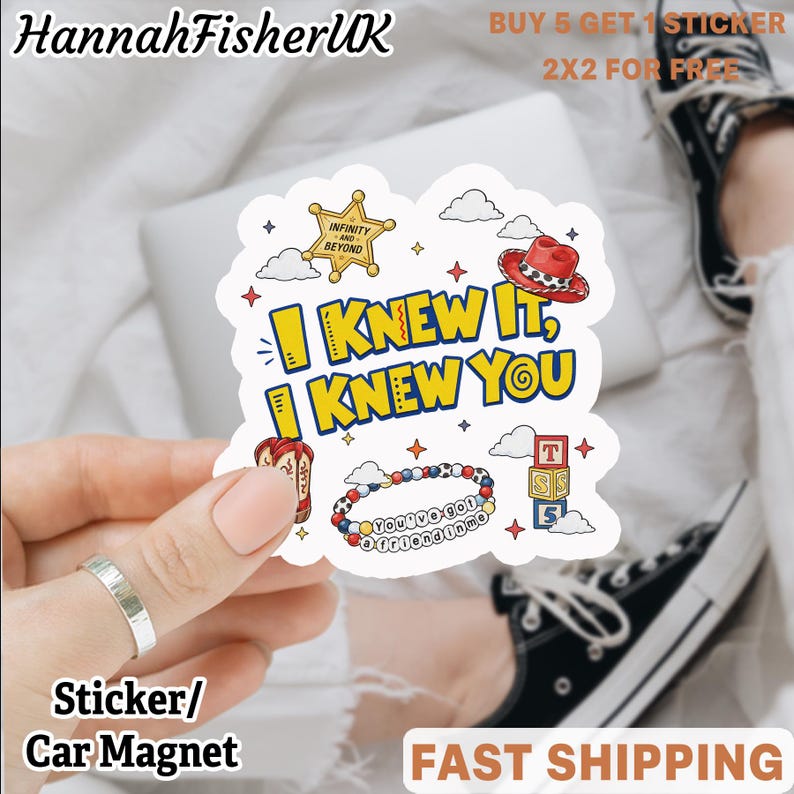 May include: A die-cut sticker featuring the yellow text I KNEW IT, I KNEW YOU, surrounded by illustrations of a gold sheriff badge, a red cowboy hat, a beaded bracelet with the text YOU'VE GOT A FRIEND IN ME, and three stacked alphabet blocks.