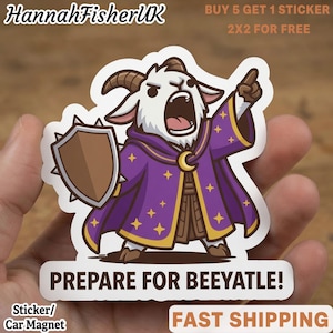 Puede incluir: Una pegatina troquelada que muestra una cabra de dibujos animados vestida con una túnica de mago morada con estrellas amarillas, sosteniendo un escudo marrón y señalando hacia arriba. El texto PREPARE FOR BEEYATLE! aparece en negro.