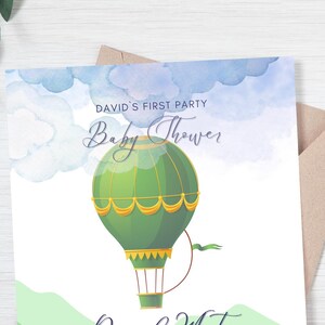 It has a whimsical and soft watercolor design featuring a hot air balloon floating in the sky with fluffy clouds. The color scheme consists of green, blue, and gold tones, creating a dreamy and elegant aesthetic.