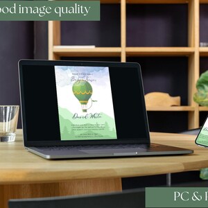 May include: A laptop and smartphone display a green hot air balloon invitation design. The laptop is open on a wooden table, with a glass of water and a bottle of water with orange slices. The text "Very good image quality" and "PC & Phone" are also visible.