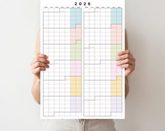 May include: A large, rectangular 2026 calendar with a grid layout, held by a person. The calendar features a minimalist design with colored vertical bars in pastel shades of blue, pink, green, yellow, and purple, and is printed on white paper.