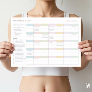 May include: A white monthly planner with a colorful grid layout, held by a person. The planner includes sections for focus, important dates, priorities, and a to-do list. The text "MONTHLY PLAN" is at the top.