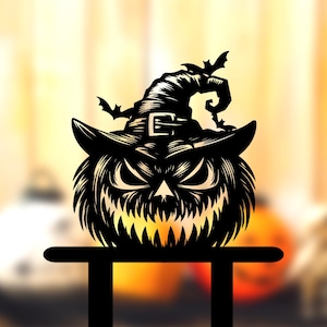 Puede incluir: Decoración negra de Halloween con una calabaza tallada que lleva un sombrero de bruja con murciélagos. La calabaza tiene una cara enfadada con dientes afilados. La decoración está montada sobre un soporte negro.
