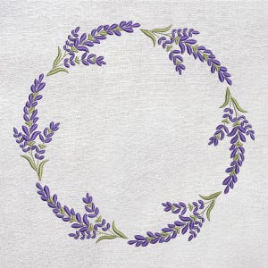 Puede incluir: Un diseño de bordado circular con ramitas de lavanda. Las ramitas son de color púrpura con hojas y tallos verdes, dispuestas en un patrón similar a una corona sobre un fondo blanco texturizado. El diseño es detallado y delicado.