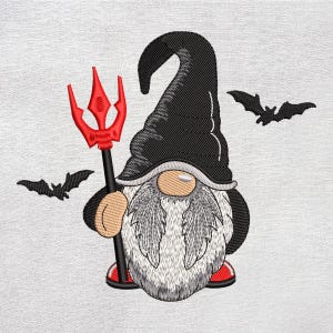 May include: Embroidered Halloween gnome holding a red trident, wearing a black hat and red shoes. The gnome has a long white beard and is flanked by two black bat silhouettes. The design is on a white background.