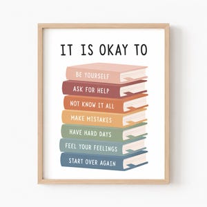 Può includere: Una stampa incorniciata che mostra una pila di sei libri colorati in tonalità rosa, rosso, arancione, giallo, verde e blu. Il testo IT IS OKAY TO è stampato sopra, con frasi su ogni dorso: BE YOURSELF, ASK FOR HELP, NOT KNOW IT ALL, MAKE MISTAKES, HAVE HARD DAYS, FEEL YOUR FEELINGS e START OVER AGAIN.