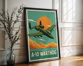 May include: Framed poster featuring a stylized illustration of an A-10 Warthog aircraft in flight. The artwork has a retro aesthetic, with a teal sky, orange sun, and tan mountains. The words "A-10 WARTHOG" are printed in white at the bottom.