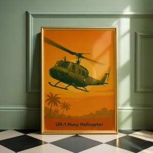Puede incluir: Impresión enmarcada que representa un helicóptero UH-1 Huey verde contra un fondo de puesta de sol naranja. La imagen incluye palmeras y el texto "UH-1 Huey Helicopter" en la parte inferior. La impresión está en un marco dorado.