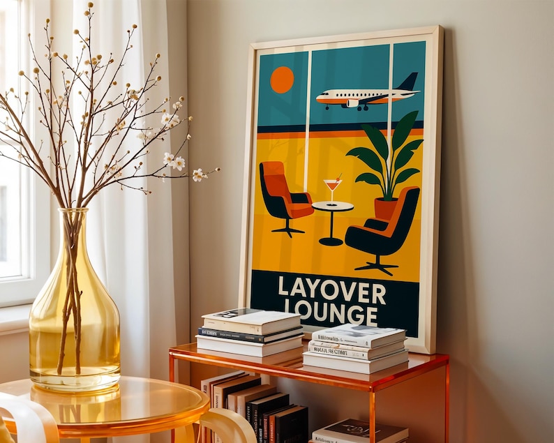 May include: A framed art print featuring a retro-style illustration of an airport lounge. The artwork depicts an airplane in flight, a sun, and lounge chairs. The words "LAYOVER LOUNGE" are printed at the bottom. The print is displayed on a wall next to a vase and books.
