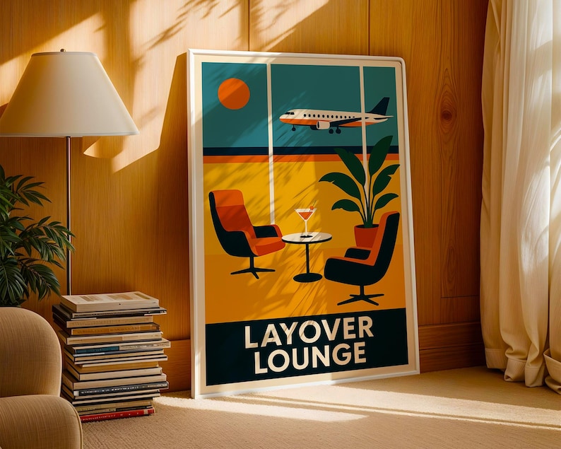 May include: A framed art print featuring a retro-style illustration of an airport layover lounge. The artwork depicts an airplane, orange sun, two chairs, a table with a drink, and a plant. The words "LAYOVER LOUNGE" are at the bottom.
