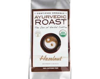 May include: A silver bag of certified organic Ayurvedic Roast Hazelnut herbal coffee. The bag features a yin yang symbol and the text "The Zen of Herbal Coffee". It is 100% caffeine free and weighs 11 ounces (312 grams).