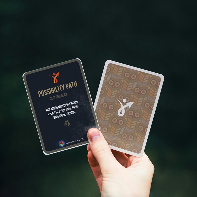 Puede incluir: Dos cartas del "Possibility Path Decision Deck" se sostienen en una mano. Una carta es azul oscuro con texto blanco y un logotipo de flecha naranja. La otra carta tiene un patr&oacute;n marr&oacute;n y beige.