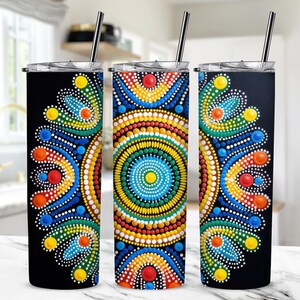 Könnte beinhalten: Drei Edelstahlbecher mit schwarzen Deckeln und bunten Punkt-Mandala-Designs. Die Designs zeigen eine Vielzahl von Farben, darunter Rot, Gelb, Blau, Grün und Weiß.