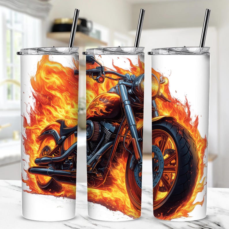 Puede incluir: Un vaso de acero inoxidable con un dise&ntilde;o de una motocicleta envuelta en llamas. La motocicleta es negra y cromada con una luz roja en la parte delantera. Las llamas son de color naranja y amarillo.