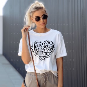 Könnte beinhalten: Weißes T-Shirt mit einem schwarzen herzförmigen Design, auf dem "Your design here" steht.