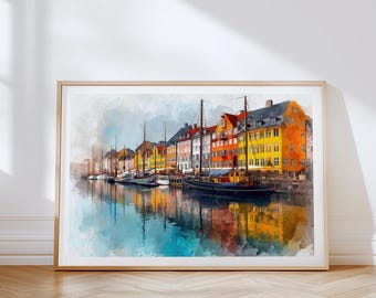 May include: Watercolor print of a waterfront scene with colorful buildings and boats. The buildings are painted in shades of yellow, orange, red, and green. The boats are docked in the water, and the sky is a light blue. The print is framed in a light wood frame.