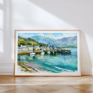May include: A framed watercolor painting of the Scottish coastal village of Ullapool, featuring white buildings along the harbor, several sailboats on the turquoise water, and rolling green mountains under a bright blue sky with clouds.