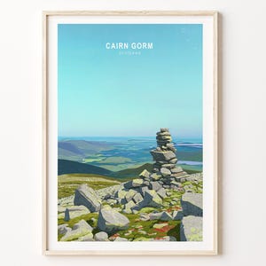 May include: A framed print featuring a landscape scene of Cairn Gorm, Scotland. The artwork depicts a stone cairn on a rocky hillside with a blue sky. The text "CAIRN GORM SCOTLAND" is at the top.