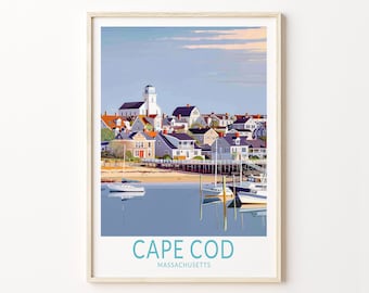 May include: A framed art print featuring a coastal town scene with a white lighthouse, colorful houses, and boats in the harbor. The words "CAPE COD MASSACHUSETTS" are printed at the bottom in teal.