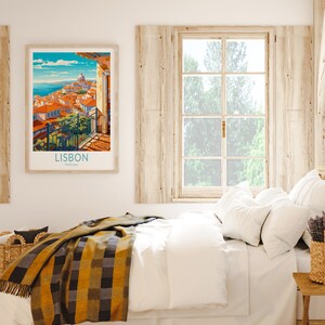 May include: A framed vintage travel poster with a colorful illustration of Lisbon, Portugal. The poster features a cityscape with buildings, a church, and a blue sky with white clouds. The text "LISBON PORTUGAL" is printed at the bottom of the poster.