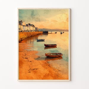 May include: Watercolor print of a coastal scene featuring a stone pier, boats, and buildings. The artwork has warm tones of orange, yellow, and brown, with a calm sea and a sunset sky. The boats are small and wooden.
