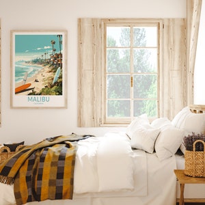 Puede incluir: Una cama blanca con una manta de cuadros amarillos y negros, almohadas blancas y un jarr&oacute;n de lavanda sobre una mesita de noche de madera. Un p&oacute;ster enmarcado con una escena de playa y el texto "MALIBU, CALIFORNIA" cuelga de la pared.