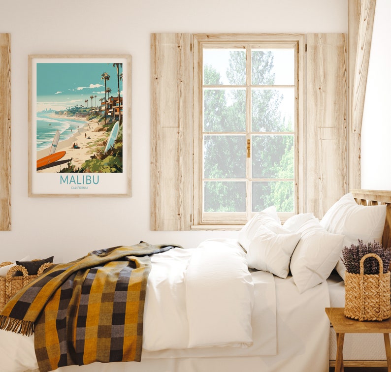 Puede incluir: Una cama blanca con una manta de cuadros amarillos y negros, almohadas blancas y un jarr&oacute;n de lavanda sobre una mesita de noche de madera. Un p&oacute;ster enmarcado con una escena de playa y el texto "MALIBU, CALIFORNIA" cuelga de la pared.