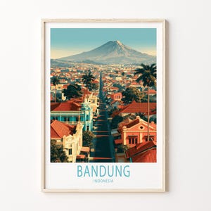 May include: A framed travel poster featuring a city street in Bandung, Indonesia, with red-roofed buildings, palm trees, and a large mountain in the background. The text BANDUNG INDONESIA is printed in light blue at the bottom of the print.