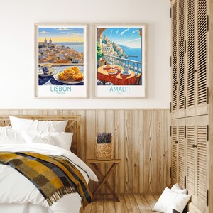 May include: Two framed travel posters with a breakfast scene in front of each. The poster on the left shows a cityscape with the text "LISBON, PORTUGAL". The poster on the right shows a coastal town with the text "AMALFI, ITALY".