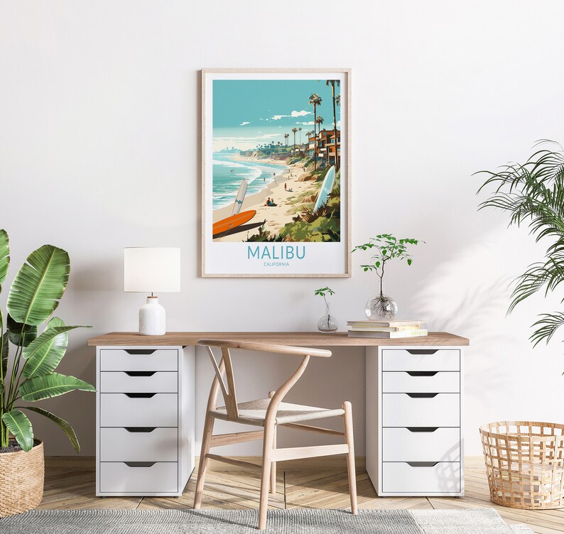 Puede incluir: Un p&oacute;ster enmarcado con una ilustraci&oacute;n colorida de una escena de playa en Malib&uacute;, California. El p&oacute;ster presenta palmeras, casas y surfistas en la playa. El texto "MALIBU, CALIFORNIA" est&aacute; impreso en la parte inferior del p&oacute;ster.